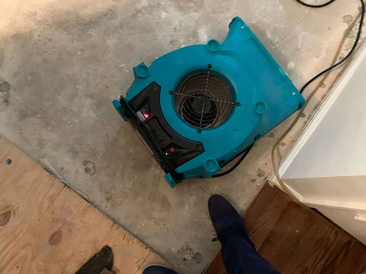 Air mover drying subfloor during Commercial Water Damage Restoration in Woburn